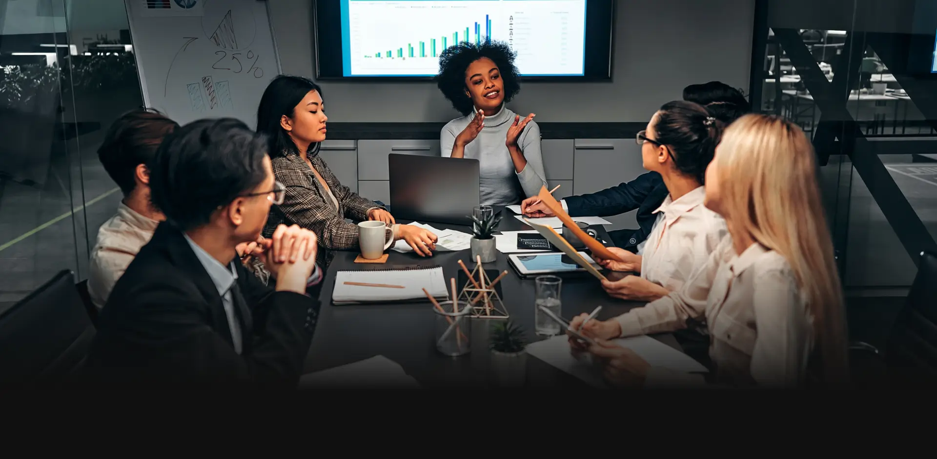 Business meeting with data projections on screen.
